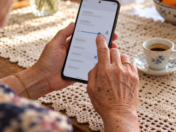 Mani di una signora regolano la dimensione del testo sullo smartphone